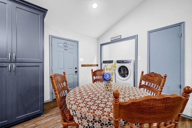 dining area with lofted ceiling, washer / clothes dryer, and wood finished floors