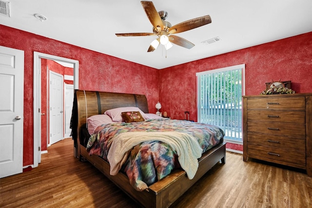 bedroom with access to outside, ceiling fan, visible vents, and wood finished floors