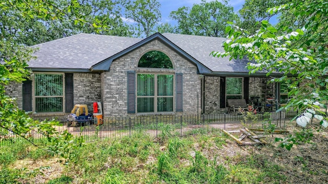 exterior space with a patio, a shingled roof, fence, and brick siding