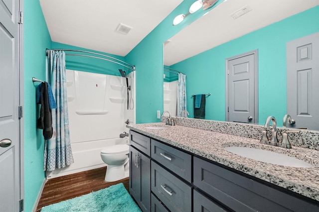 bathroom featuring visible vents, a sink, wood finished floors, and double vanity