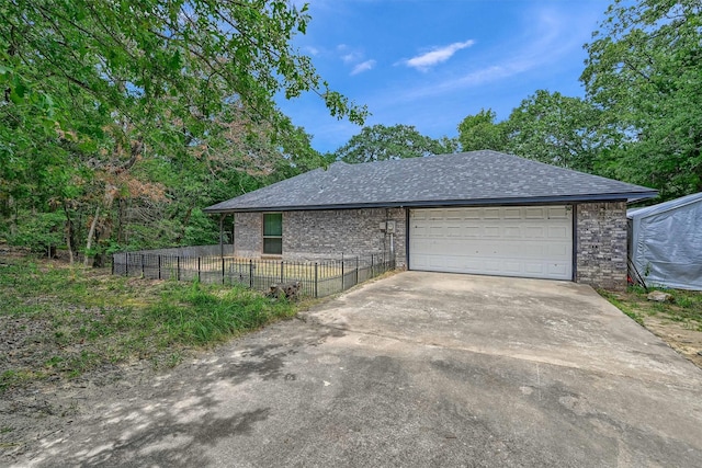 garage with fence and concrete driveway