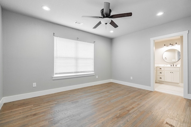 unfurnished bedroom featuring light wood finished floors, a sink, visible vents, and recessed lighting