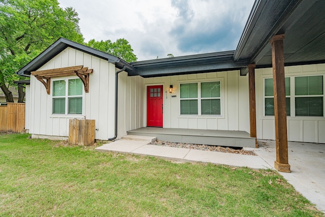 view of front of house featuring board and batten siding, a porch, fence, and a front yard