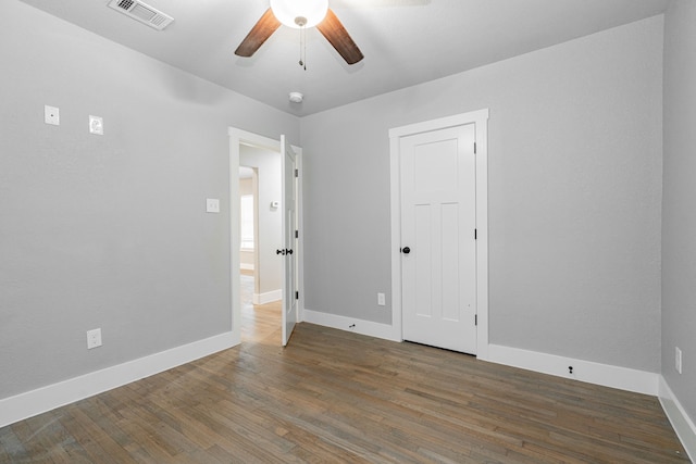 unfurnished room with ceiling fan, baseboards, wood finished floors, and visible vents