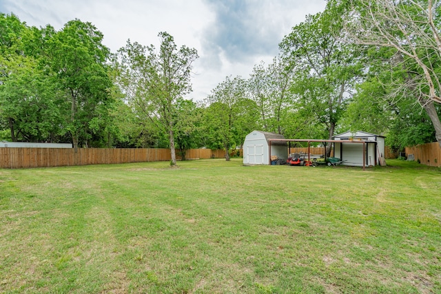view of yard with fence, an outbuilding, and a storage shed