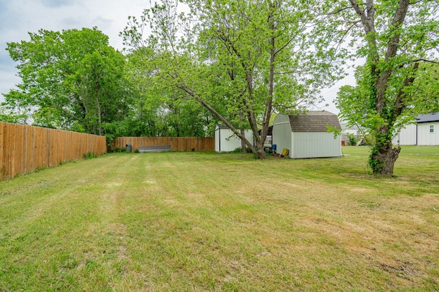 view of yard with fence, an outbuilding, and a storage shed