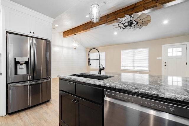 kitchen with white cabinets, a sink, stone counters, vaulted ceiling with beams, and appliances with stainless steel finishes