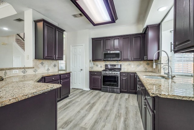 kitchen featuring light stone countertops, visible vents, a sink, and appliances with stainless steel finishes