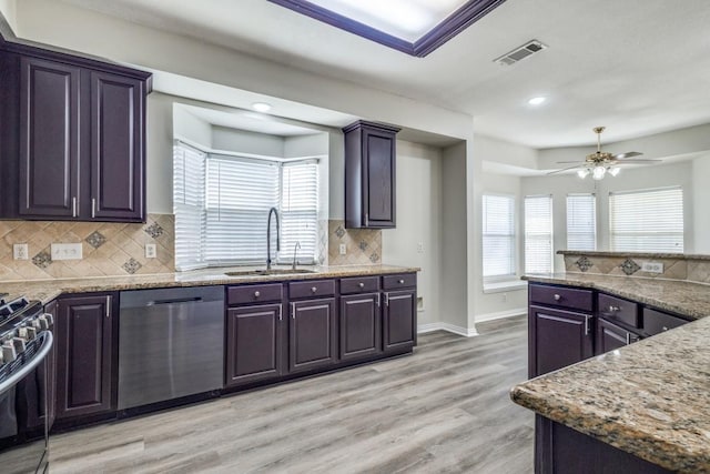 kitchen featuring a sink, decorative backsplash, light wood finished floors, appliances with stainless steel finishes, and visible vents