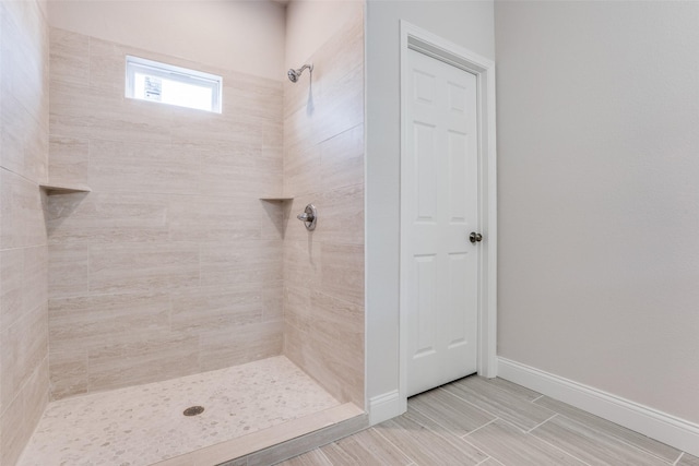 full bathroom featuring baseboards and tiled shower