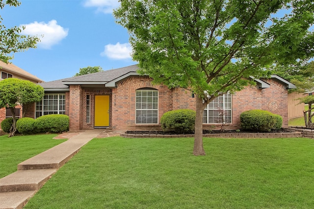 single story home featuring brick siding, a shingled roof, and a front lawn