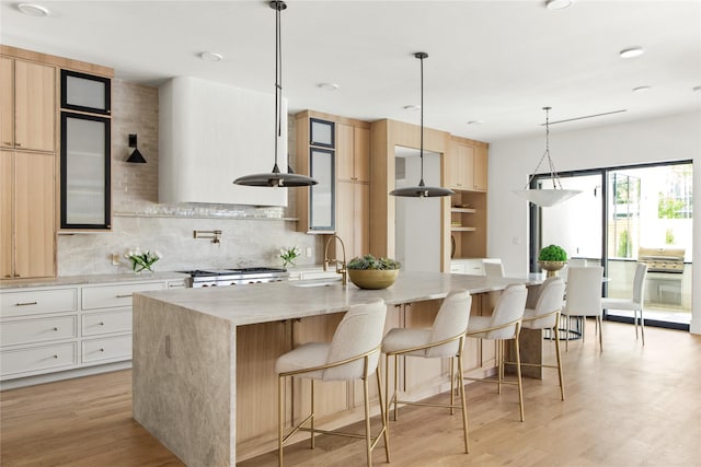 11736 Jamestown Rd, Dallas, TX 75230 - kitchen featuring modern cabinets, stainless steel double oven, tasteful backsplash, and light wood-type flooring