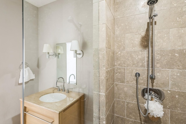 bathroom featuring a tile shower and vanity