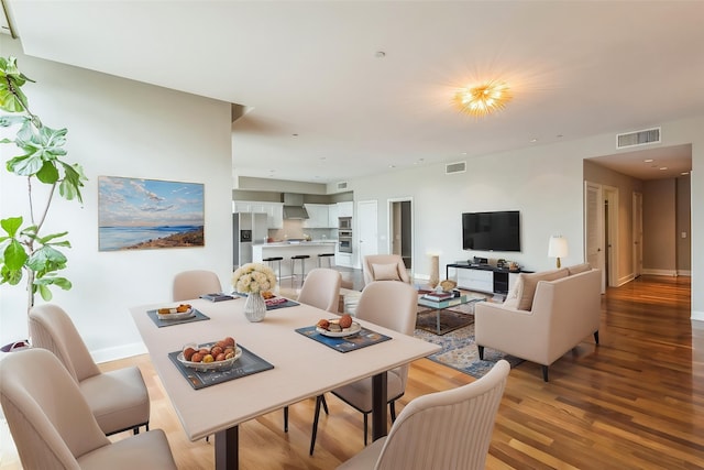 dining space with baseboards, visible vents, and light wood-style flooring