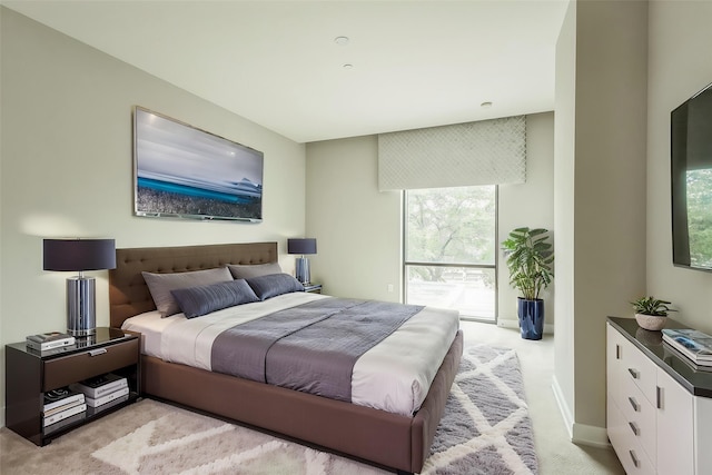 bedroom featuring baseboards and light colored carpet