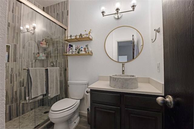 full bathroom featuring a stall shower, wood finished floors, vanity, and toilet