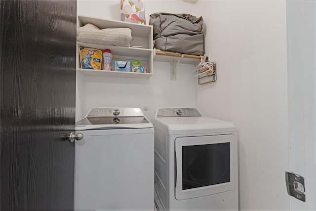 clothes washing area with washing machine and clothes dryer and laundry area