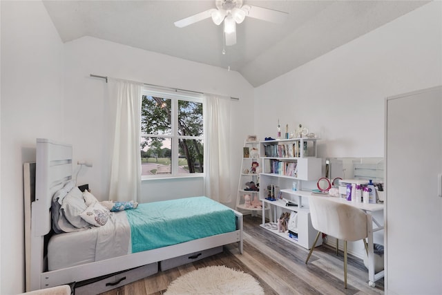 bedroom with vaulted ceiling, a ceiling fan, and wood finished floors