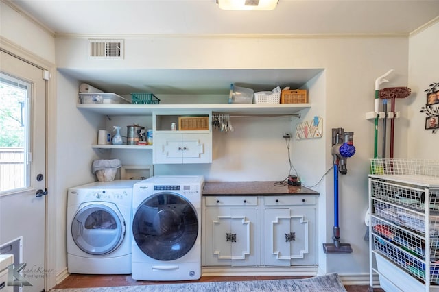 clothes washing area with visible vents, ornamental molding, baseboards, washer and dryer, and cabinet space