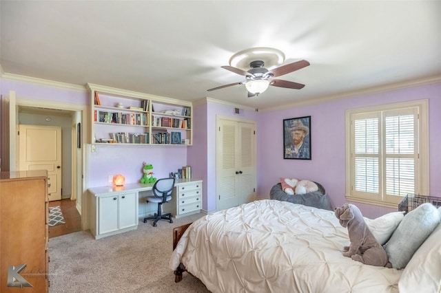 bedroom featuring a ceiling fan, a closet, light colored carpet, ornamental molding, and visible vents