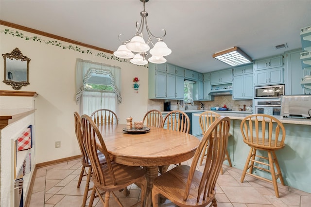 dining area featuring visible vents, light tile patterned flooring, crown molding, baseboards, and a notable chandelier