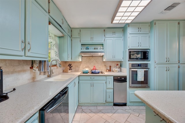 kitchen with a sink, visible vents, backsplash, under cabinet range hood, and appliances with stainless steel finishes