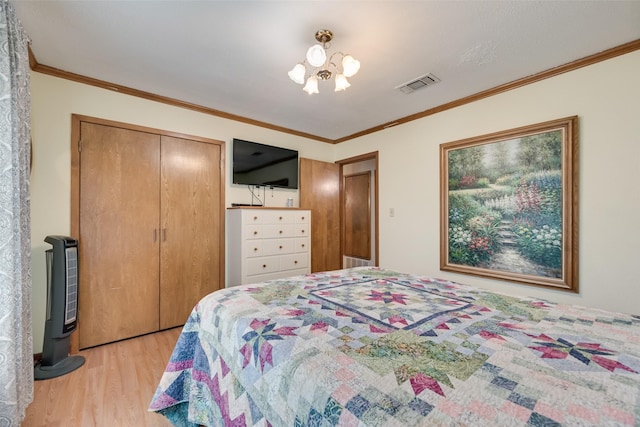 bedroom featuring ornamental molding, light wood finished floors, visible vents, and a closet