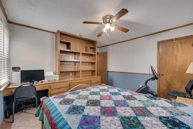 bedroom with wainscoting, ornamental molding, visible vents, and light tile patterned floors
