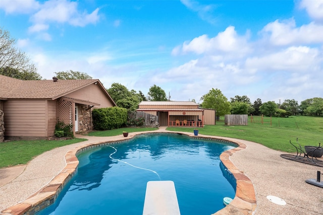 view of pool featuring a lawn, a diving board, fence, a patio, and a fenced in pool