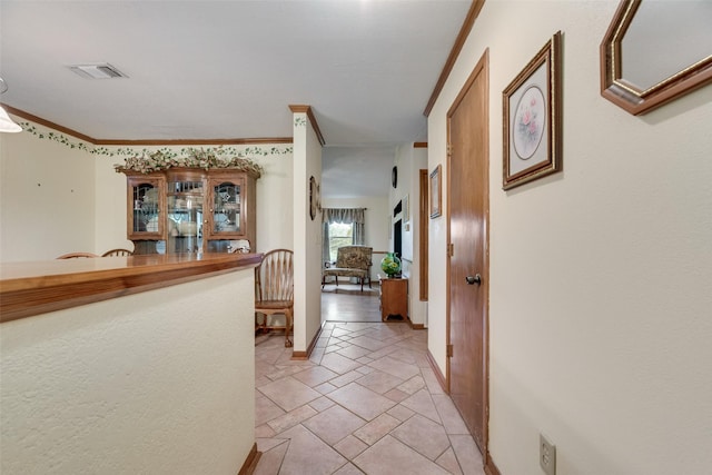 hall with baseboards, visible vents, and crown molding