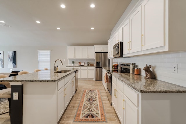 5753 Brookville Dr, Fort Worth, TX 76179 - kitchen with stainless steel appliances, a sink, white cabinetry, decorative backsplash, and recessed lighting