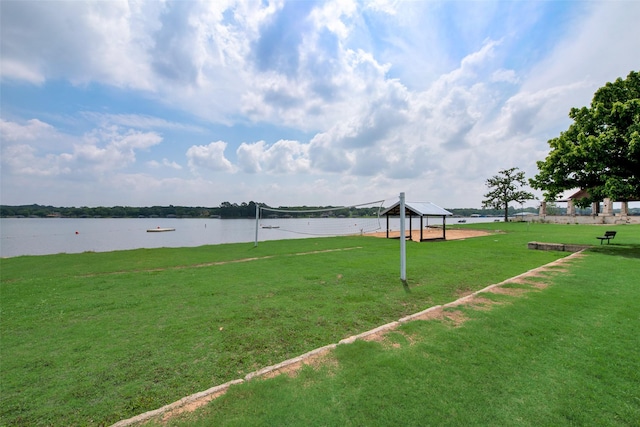 view of property's community with volleyball court, a gazebo, a water view, and a yard