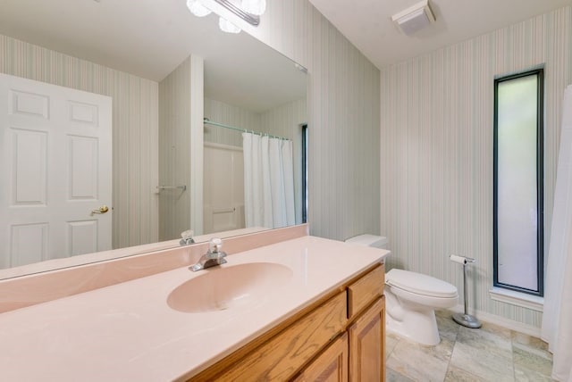 104 Kiowa Dr N, Gainesville, TX 76240 - full bathroom with toilet, vanity, visible vents, baseboards, and wallpapered walls