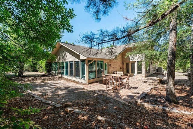 104 Kiowa Dr N, Gainesville, TX 76240 - back of property with roof with shingles, a patio, a sunroom, and brick siding