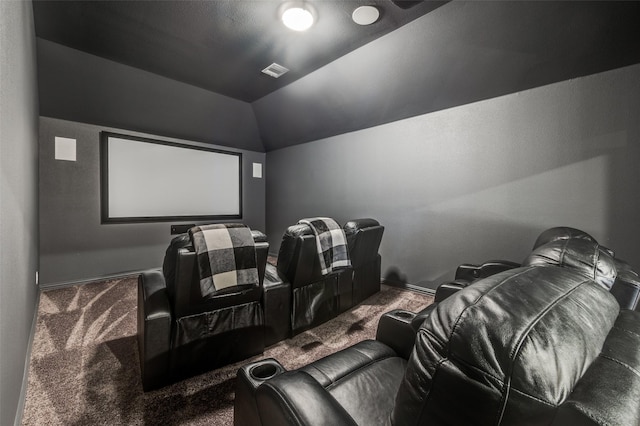 carpeted cinema room featuring vaulted ceiling and visible vents
