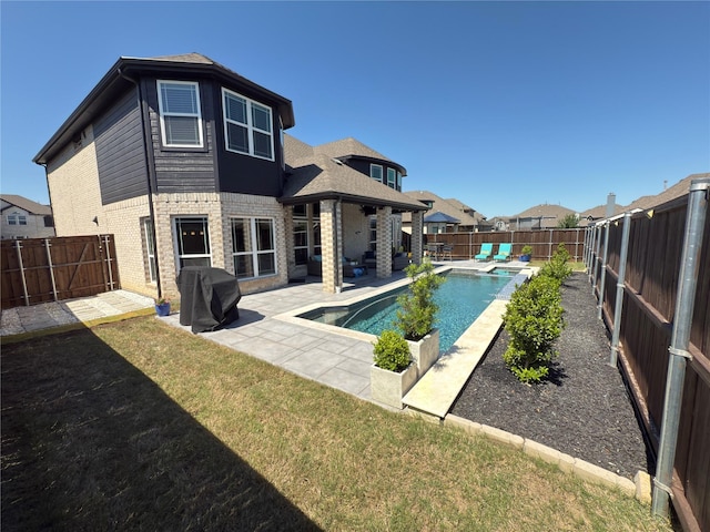 rear view of house with a patio, brick siding, a yard, and a fenced backyard