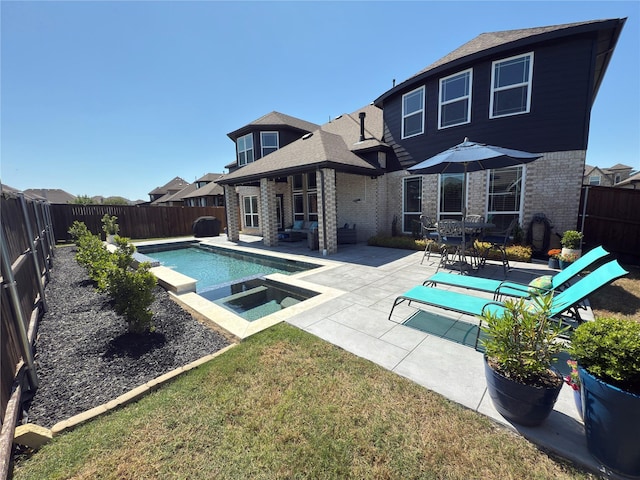back of house featuring brick siding, a fenced backyard, a fenced in pool, a patio, and a yard