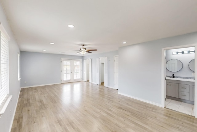 unfurnished living room with light wood finished floors, a sink, baseboards, recessed lighting, and a ceiling fan