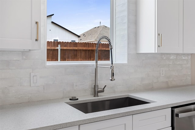 5426 Van Horn Dr, Granbury, TX 76048 - kitchen featuring dishwasher, a sink, light stone countertops, tasteful backsplash, and white cabinetry