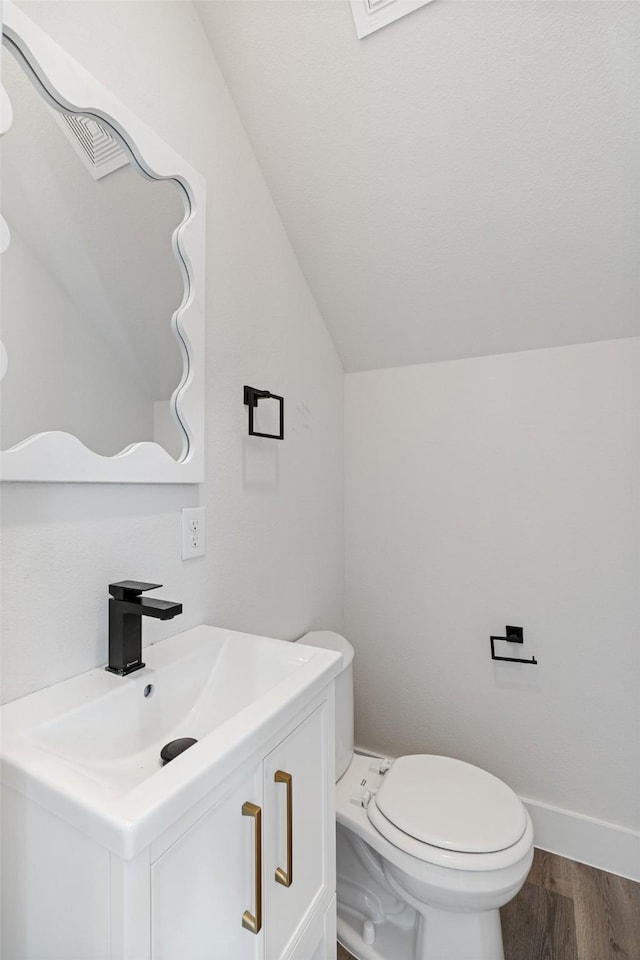 5426 Van Horn Dr, Granbury, TX 76048 - bathroom with toilet, vaulted ceiling, baseboards, wood finished floors, and vanity