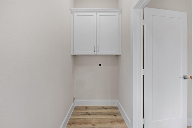 5426 Van Horn Dr, Granbury, TX 76048 - laundry area with light wood-type flooring, electric dryer hookup, baseboards, and cabinet space