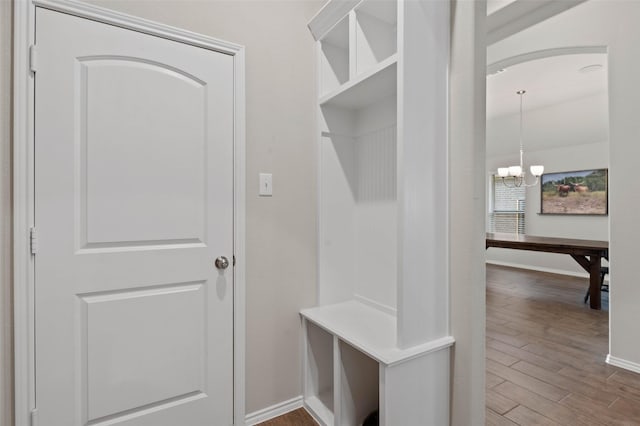 mudroom with baseboards, wood finished floors, and a chandelier