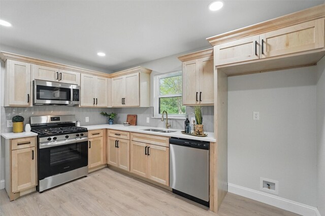 841 Lake Terrace Cir, Dallas, TX 75218 - kitchen featuring stainless steel appliances, light brown cabinets, a sink, light wood finished floors, and tasteful backsplash