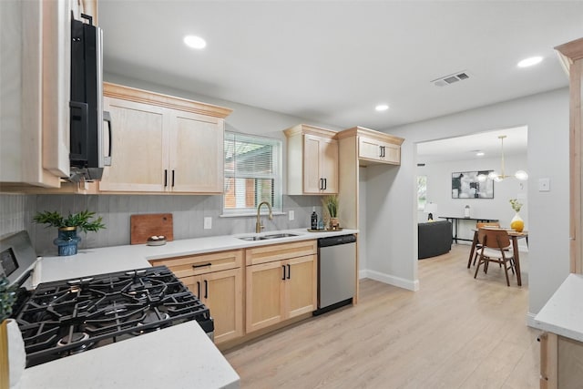 841 Lake Terrace Cir, Dallas, TX 75218 - kitchen featuring light brown cabinetry, gas range, a sink, dishwasher, and light wood-style floors