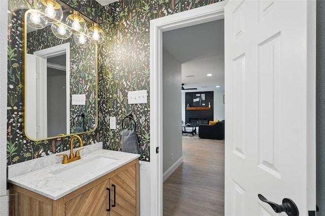 841 Lake Terrace Cir, Dallas, TX 75218 - bathroom featuring wood finished floors, vanity, wallpapered walls, a chandelier, and baseboards