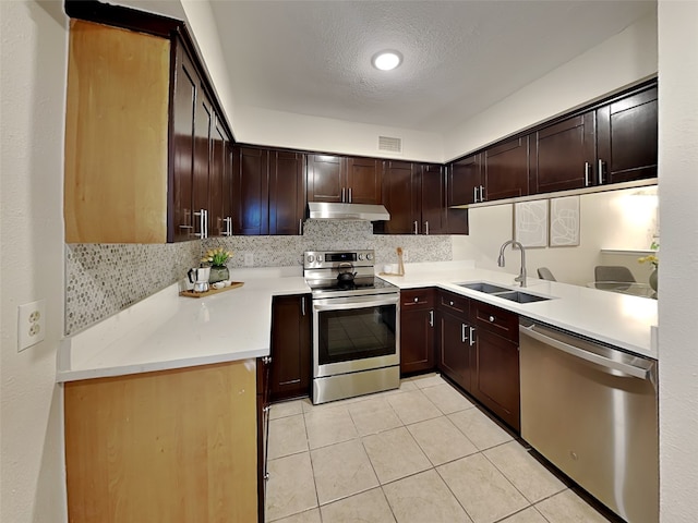 kitchen featuring under cabinet range hood, stainless steel appliances, visible vents, light tile patterned floors, and a sink
