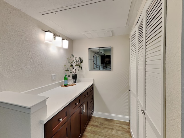 bathroom featuring baseboards, wood finished floors, and vanity