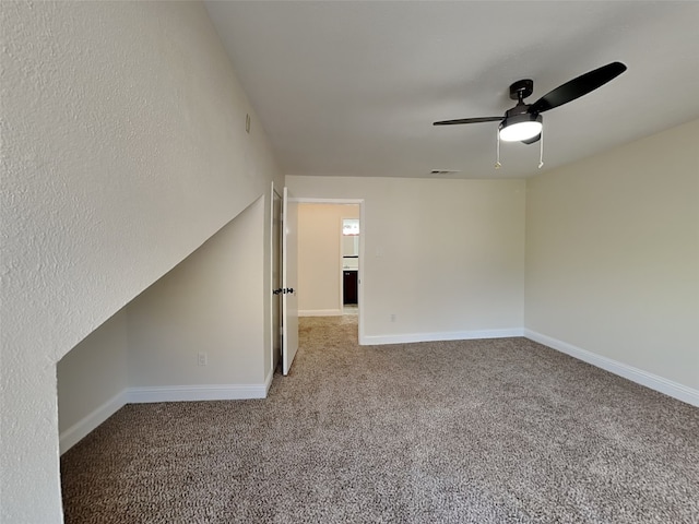 carpeted spare room featuring baseboards, a ceiling fan, and visible vents