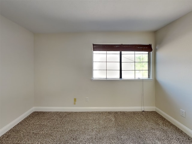 spare room with baseboards and carpet floors