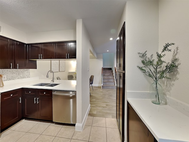 kitchen with dishwasher, a sink, light countertops, and light tile patterned floors